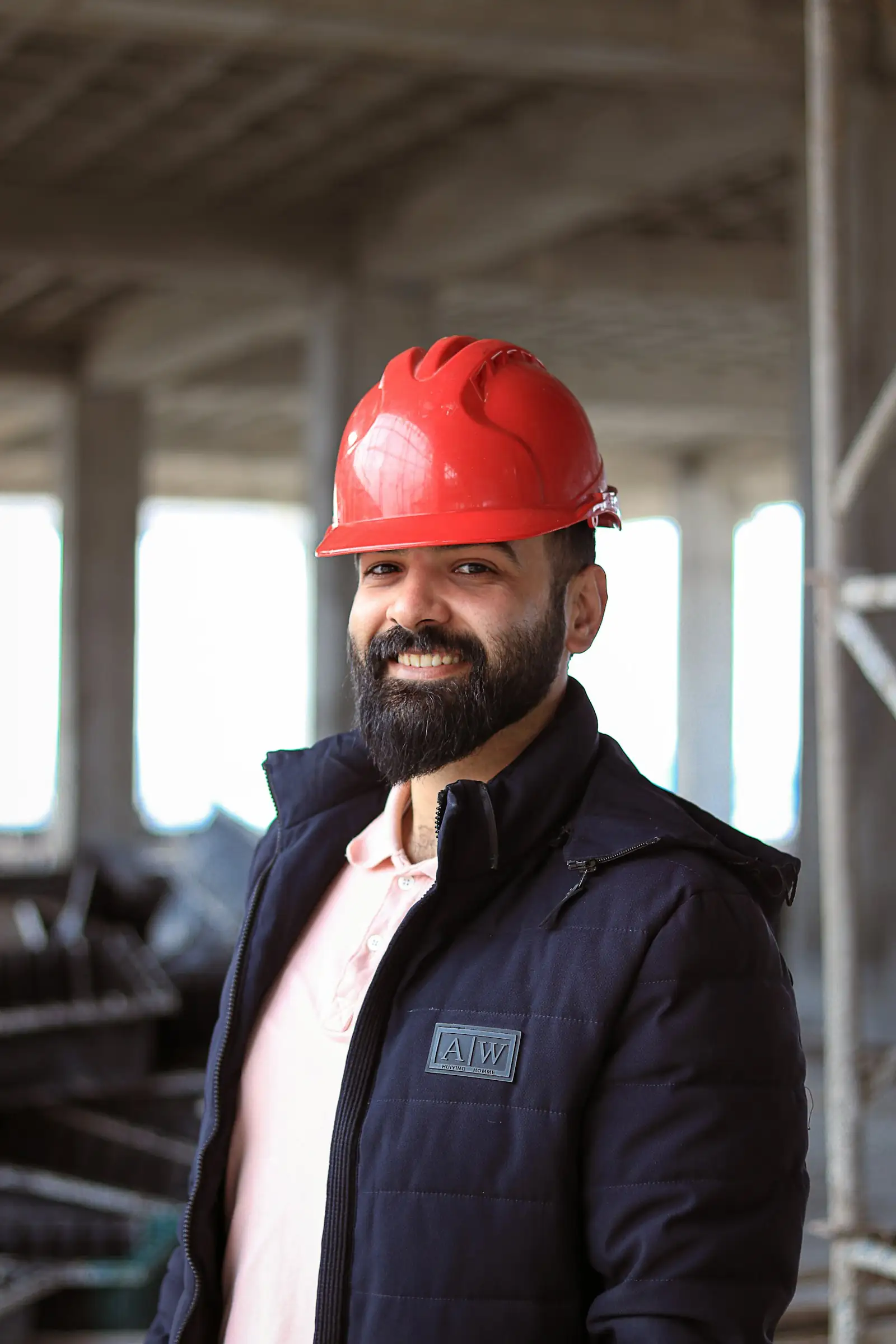Builder in a red hard hat smiling on site