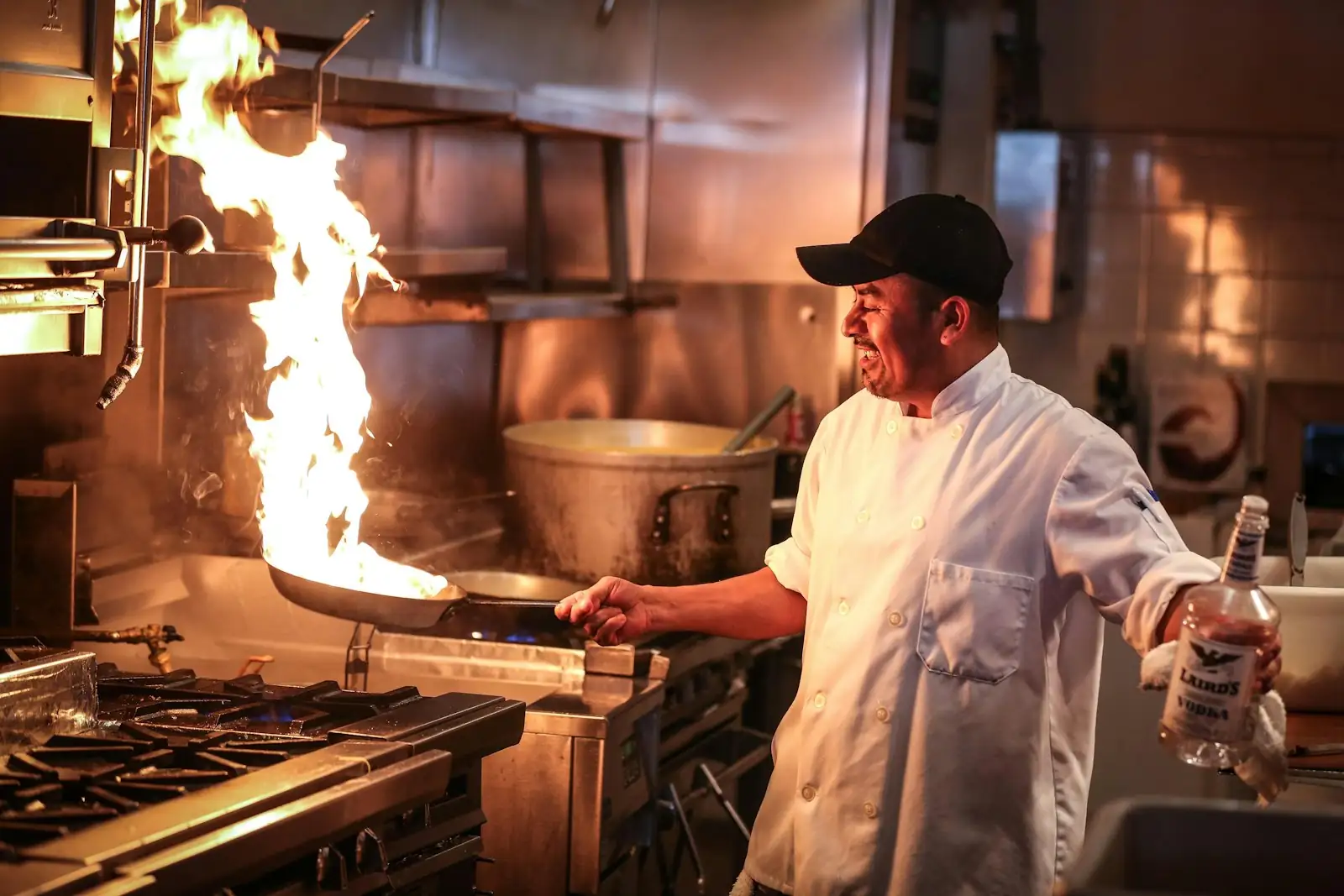 Chef cooking over a flaming wok in a commercial kitchen