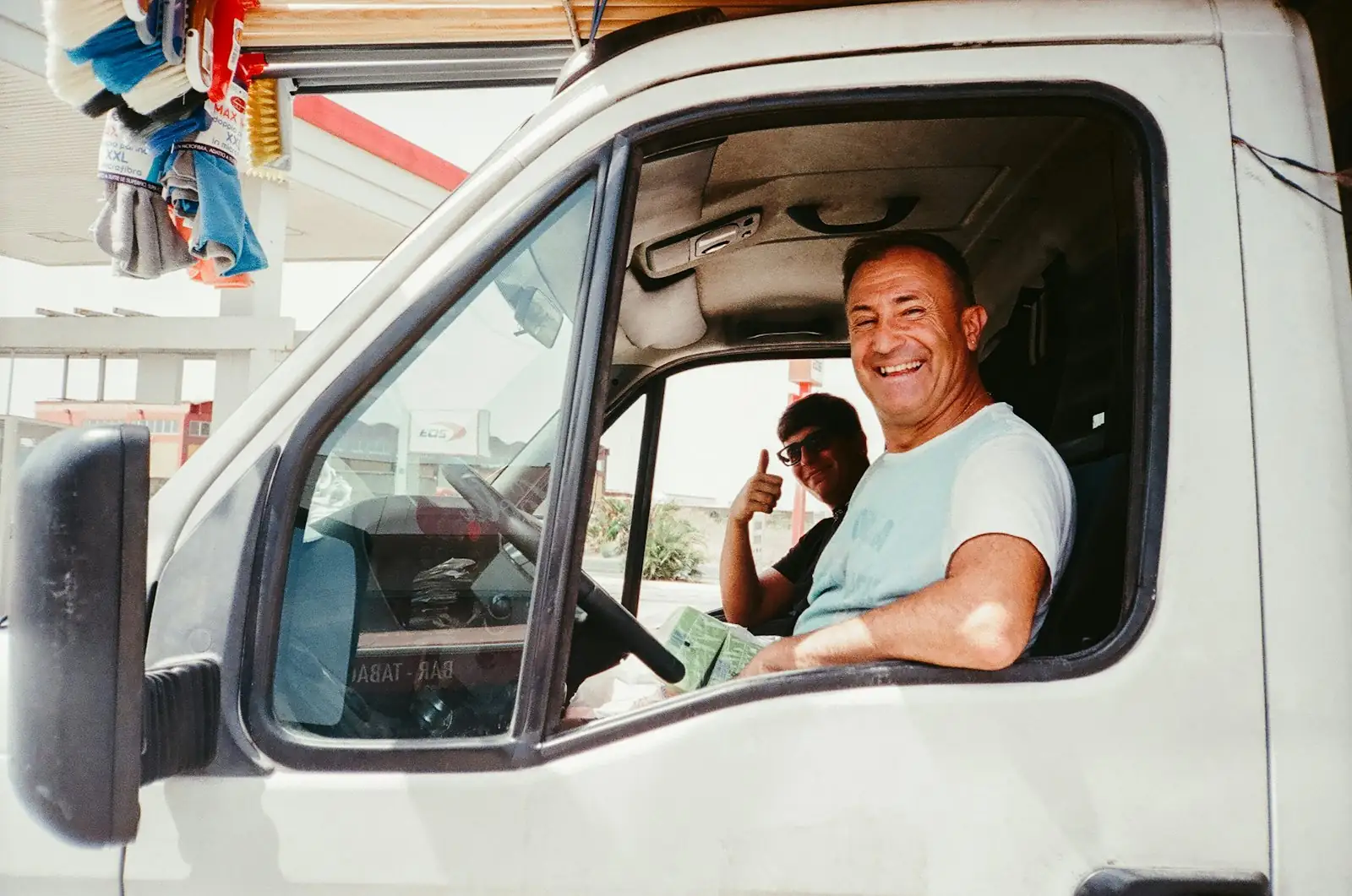 Smiling delivery driver giving a thumbs up from his van