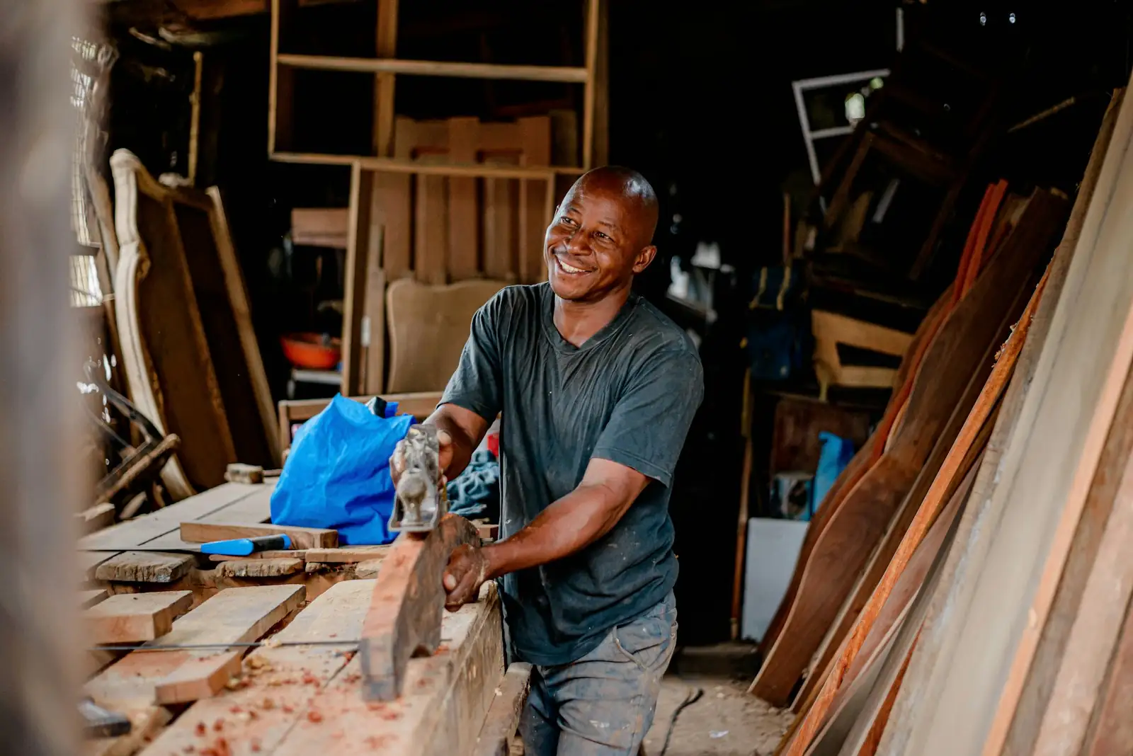 Smiling joiner working timber in his workshop